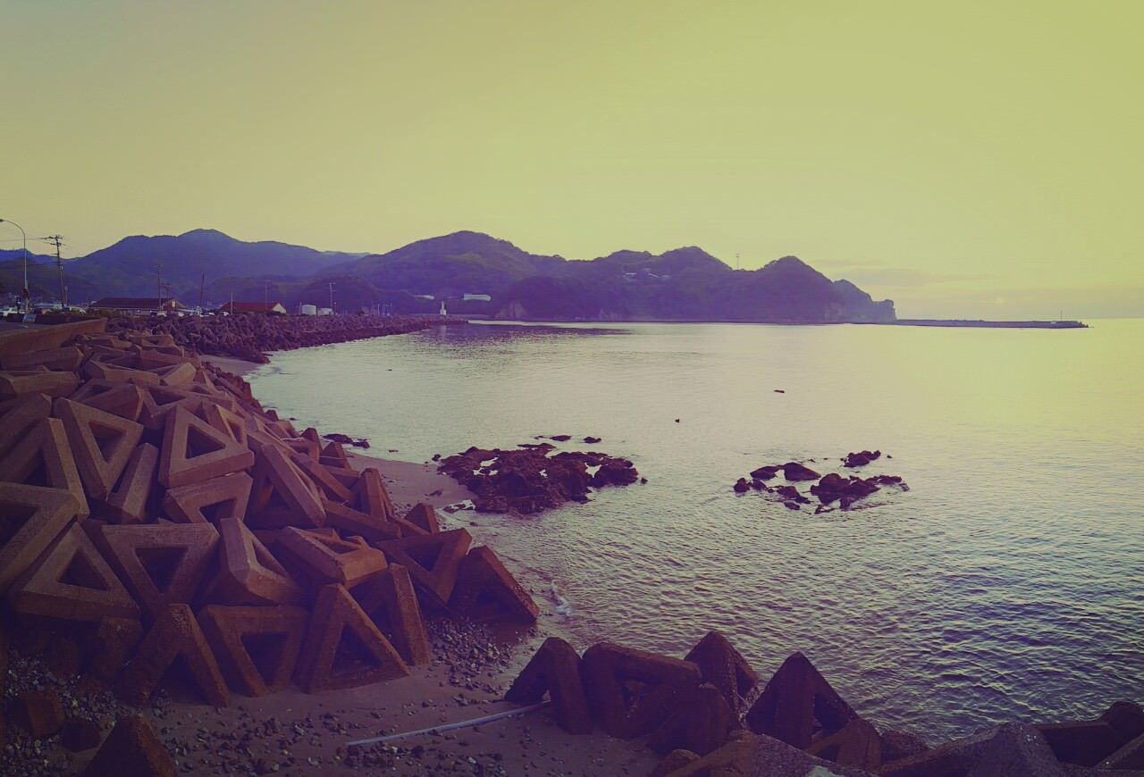 Standing on the wall looking back towards the mouth of the marina, we can see a lot of anti-erosion bolards in the sand