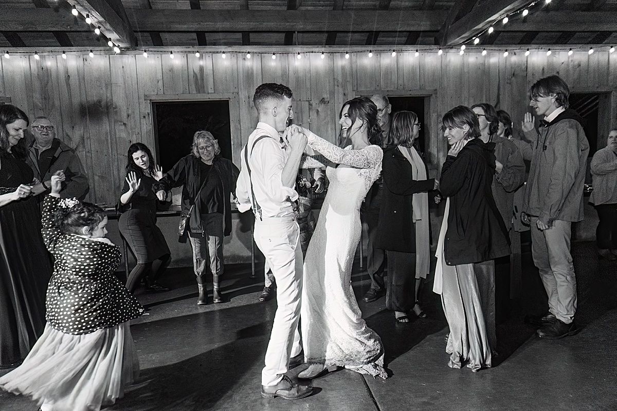 Photo of bride and groom dancing surrounded by wedding guests at reception
