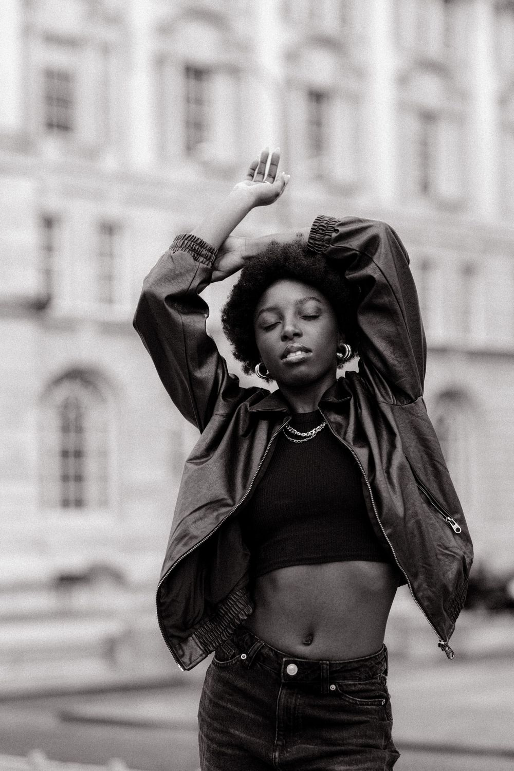 Black and white fashion series showing expressive dance-like movements against architectural backdrop.