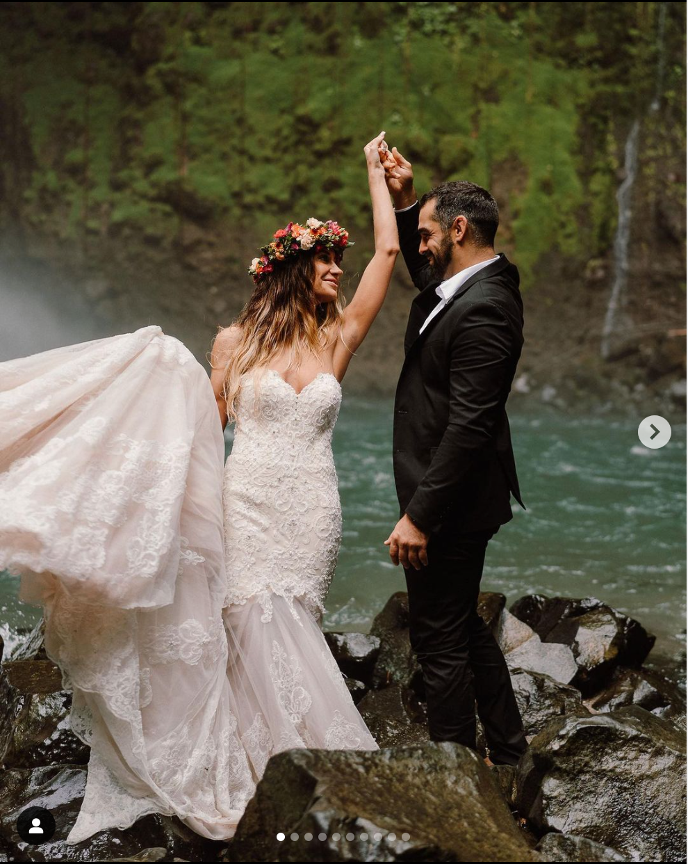 A celebratory moment captured on rocky riverbank with turquoise water and forest background.