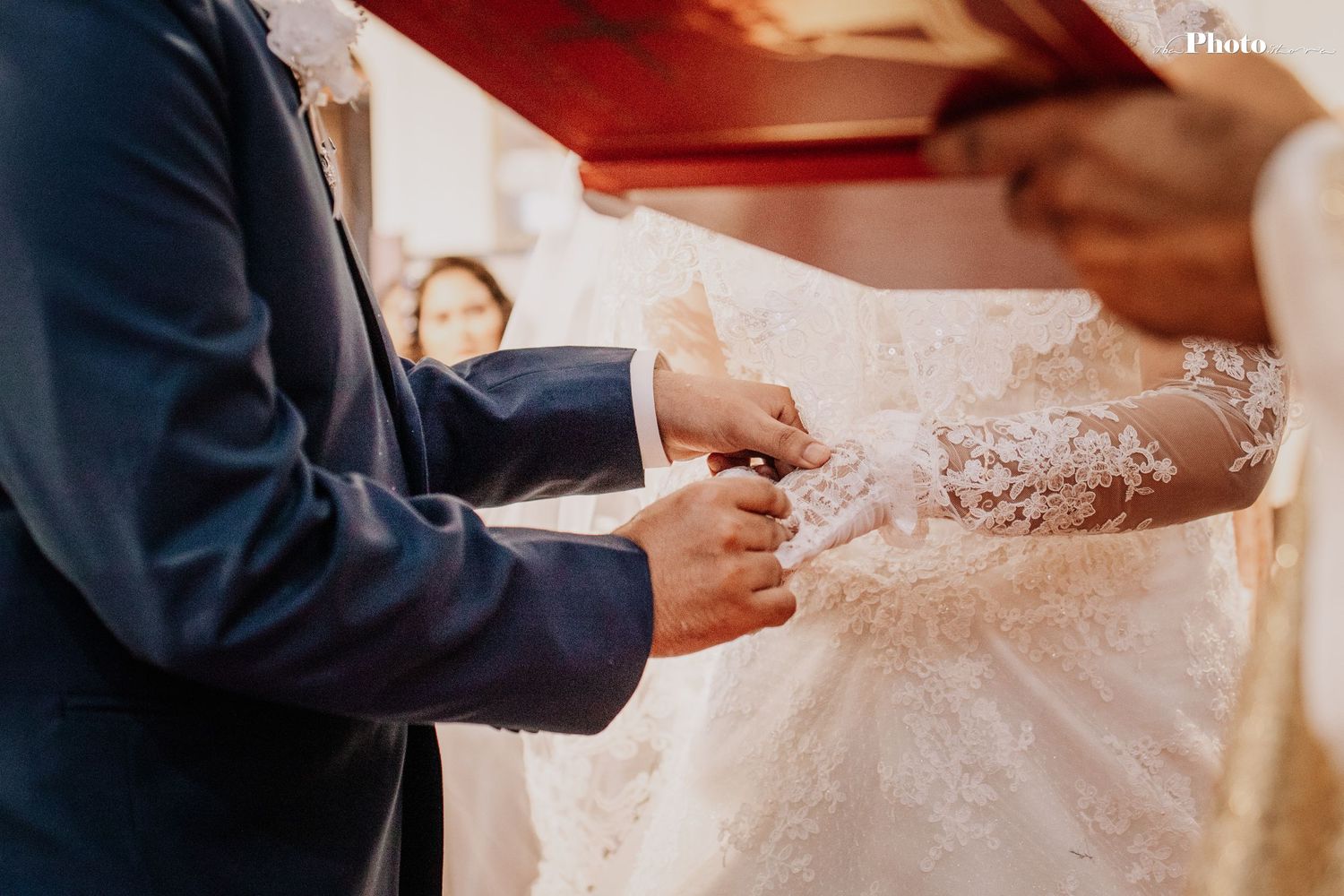 Detail shot of wedding dress lace and formal attire during ceremony.