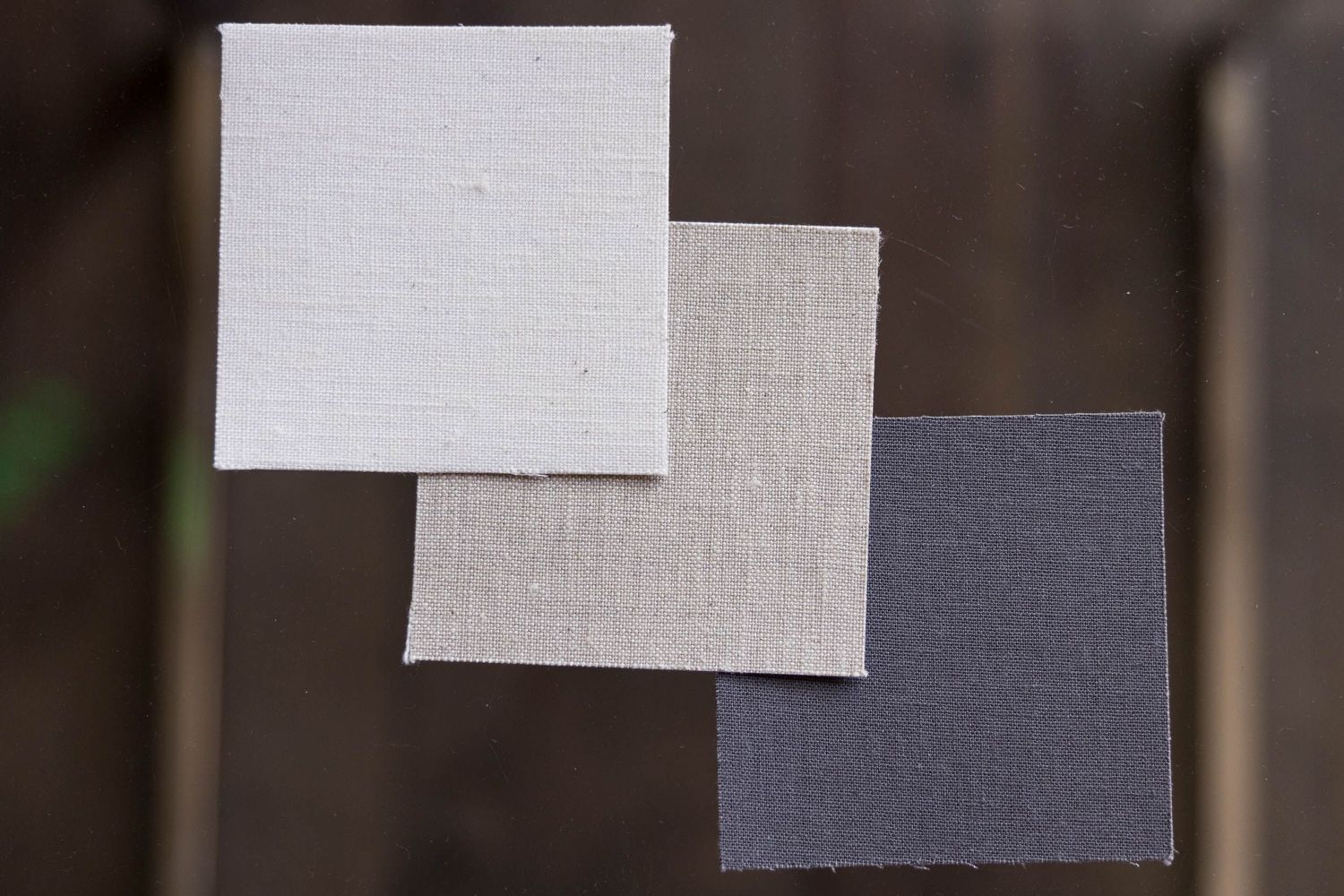 Three fabric swatches in white, light gray, and charcoal arranged diagonally.
