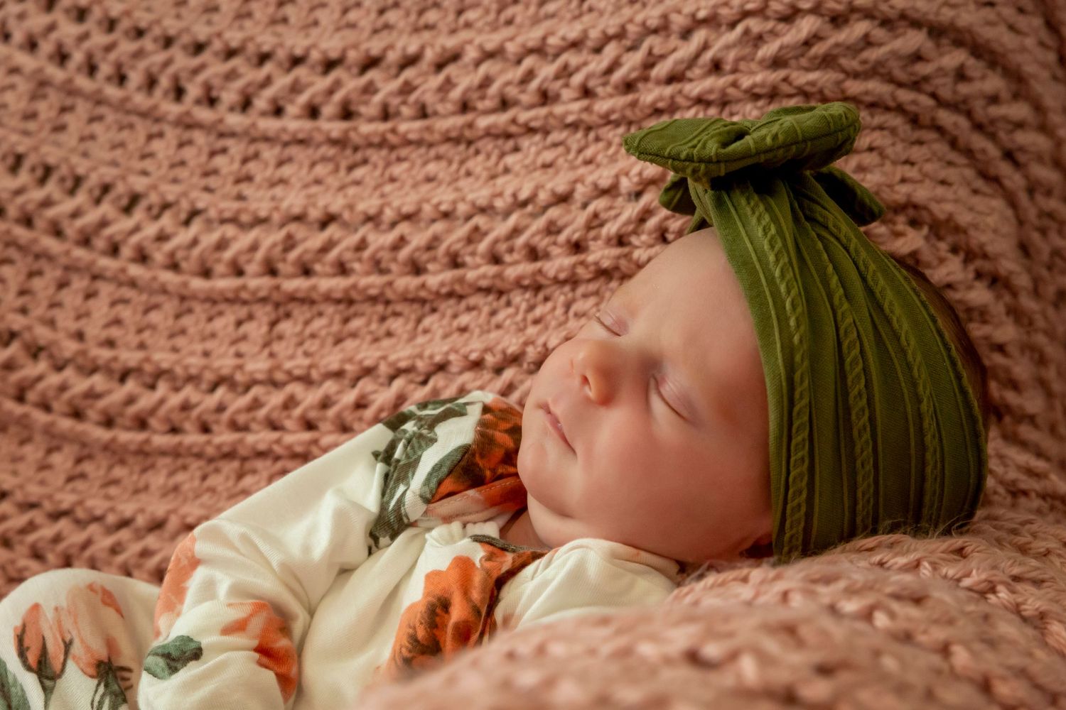 newborn girl on pink blanket sleeping