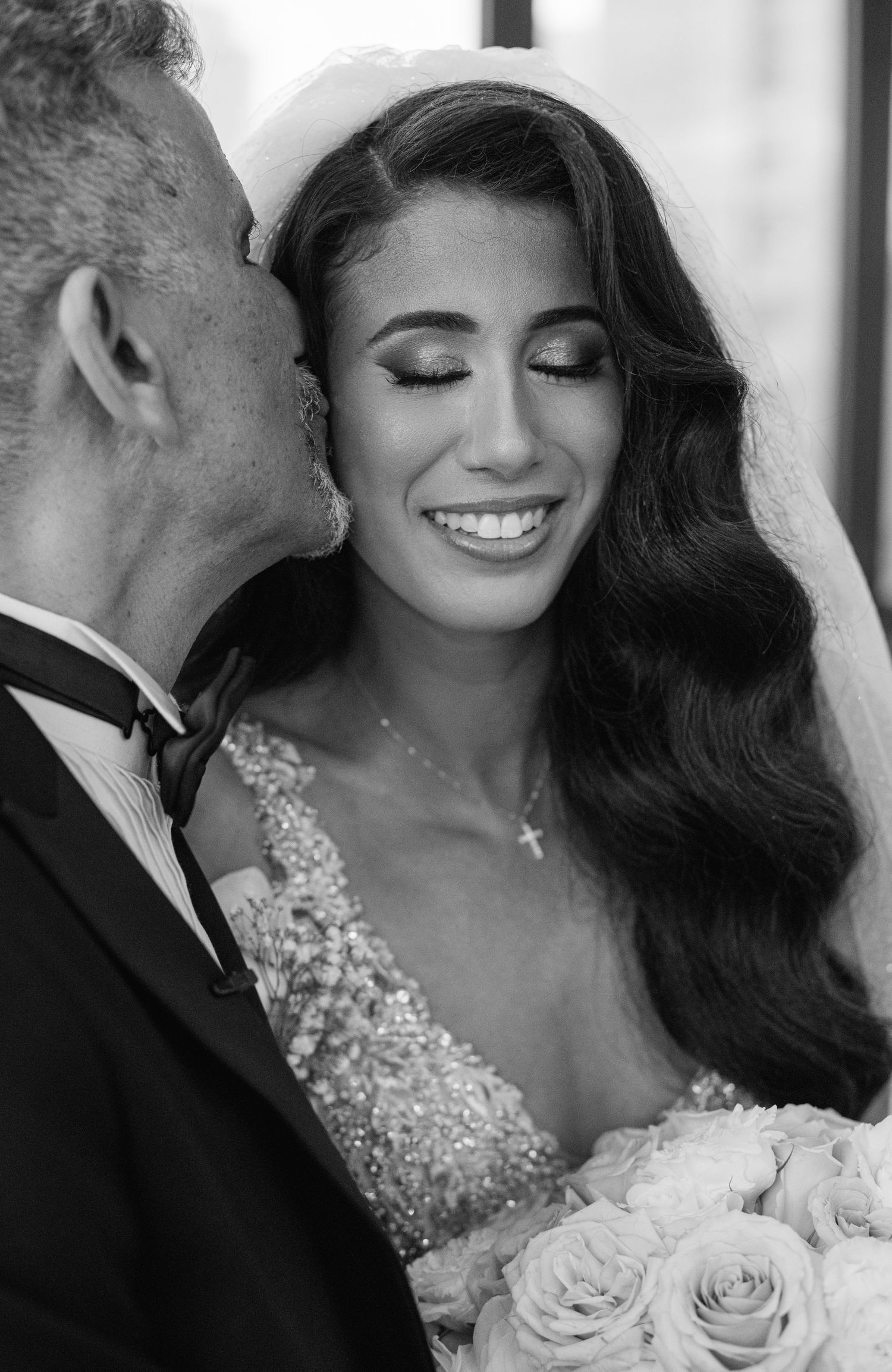 Intimate black and white portrait of newlyweds with roses.