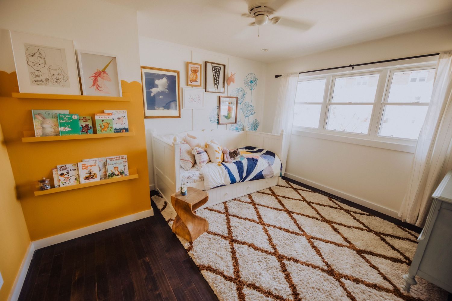 Bedroom with geometric patterned bedding and orange accent wall.