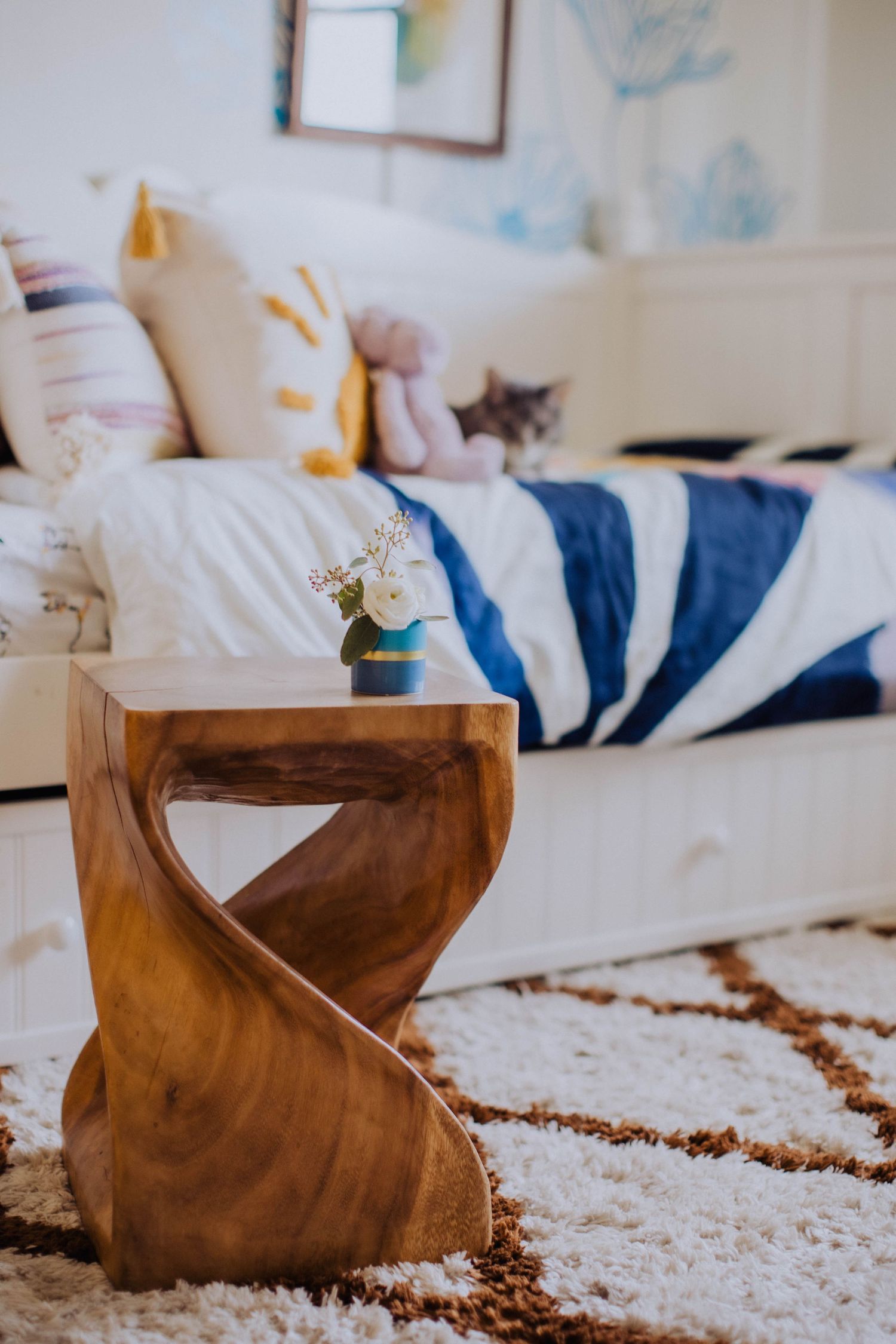 Close-up of a wooden rocking chair on a plush geometric area rug in a nursery setting.