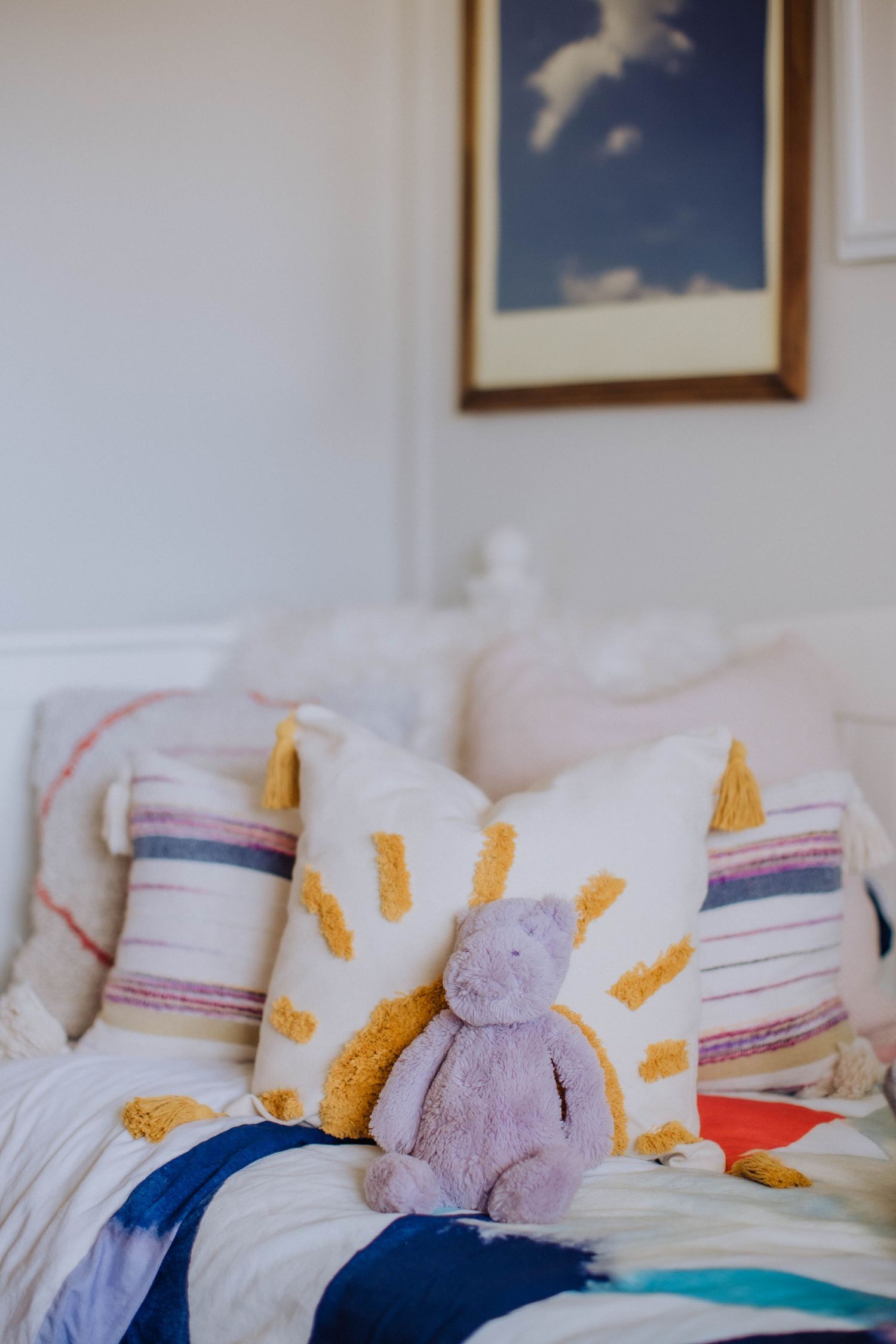 Close-up view of bedding with yellow and pink decorative elements.