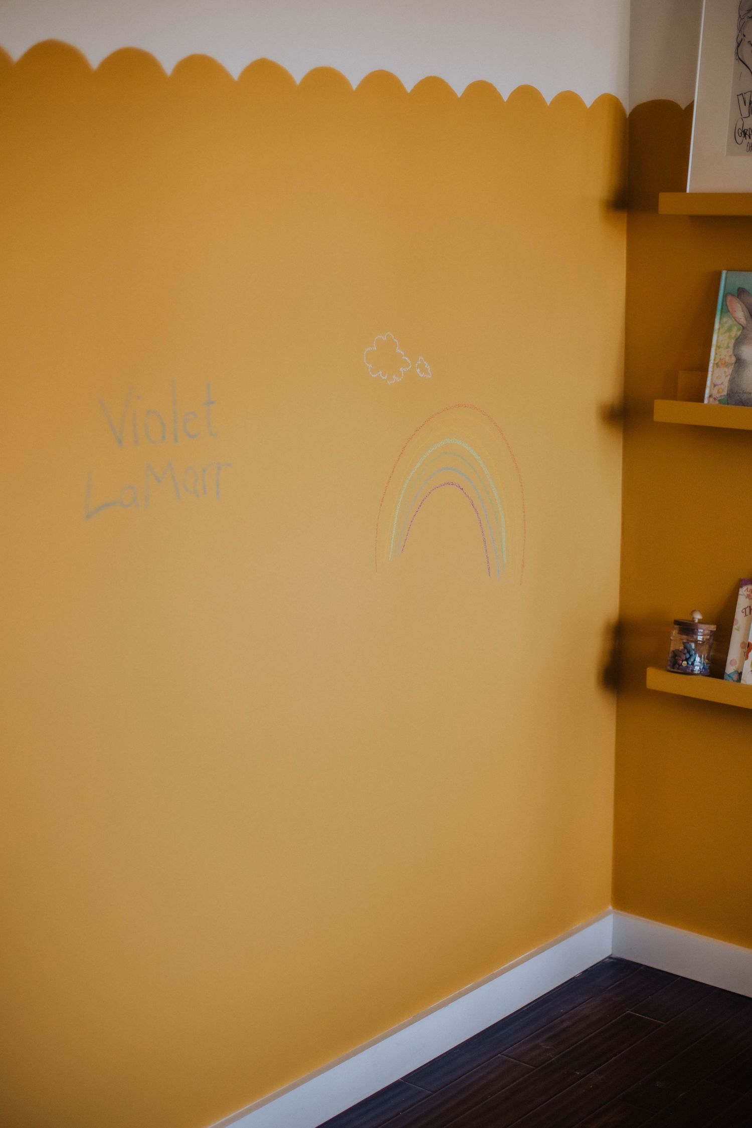 Yellow painted wall with decorative scalloped border detail near the ceiling.