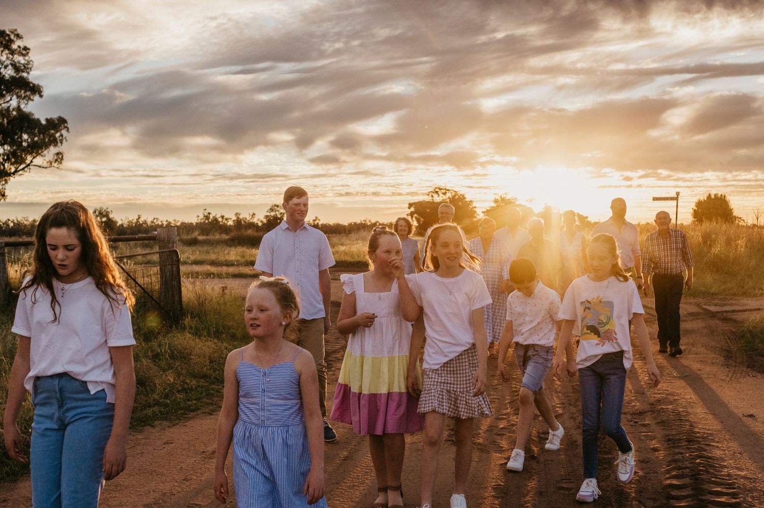 Extended family in the golden light walking together in a rural paddock