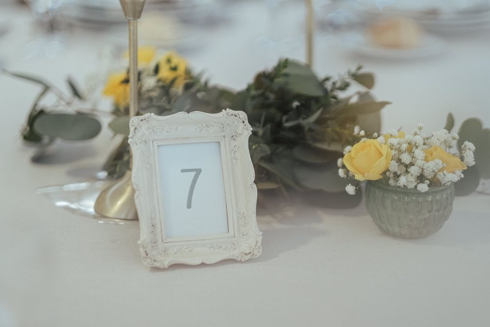 Decoração de mesa de casamento com delicados marcadores de lugar e arranjos florais.