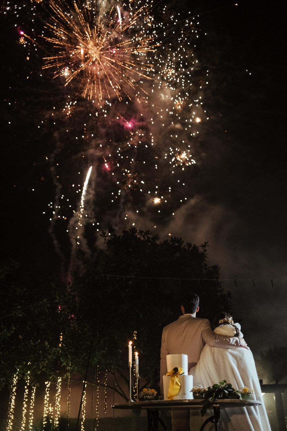 Um espetáculo de fogo de artifício colorido ilumina o céu noturno durante a celebração.