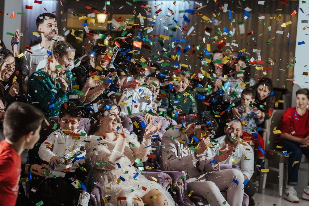 Celebração de casamento com confettis coloridos a serem lançados ao ar durante um momento de alegria.