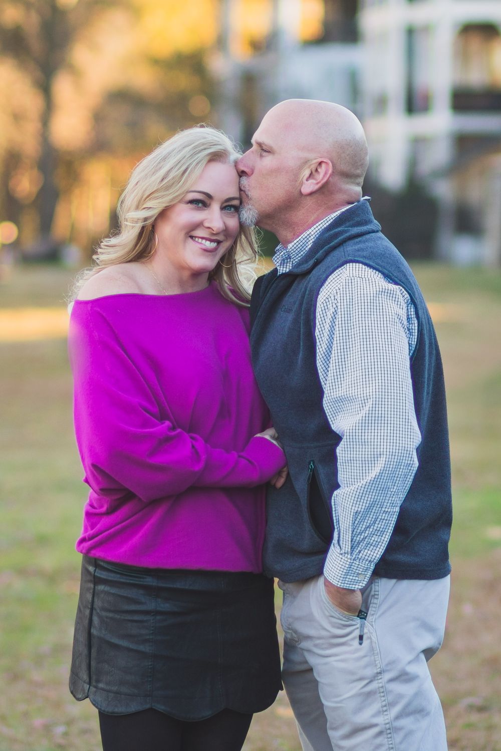 A tender moment between a couple outdoors with golden sunset lighting in the background.