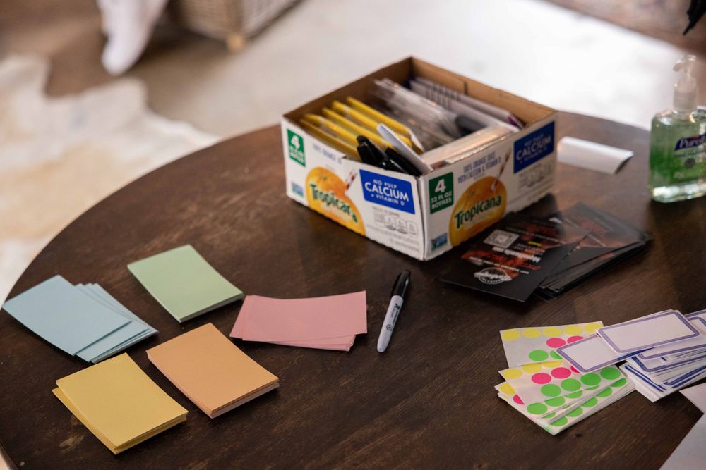 Colorful sticky notes and office supplies arranged on wooden table surface.