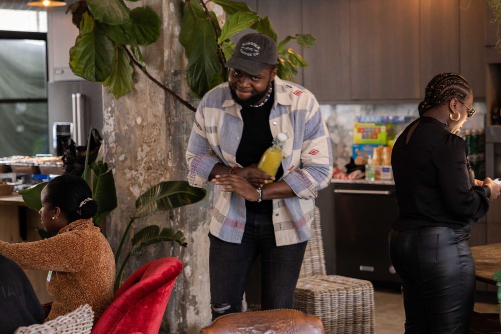 Person checking phone near indoor plant in modern restaurant setting.