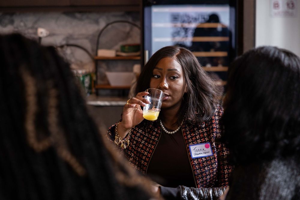 People enjoying drinks and conversation at social gathering indoors.