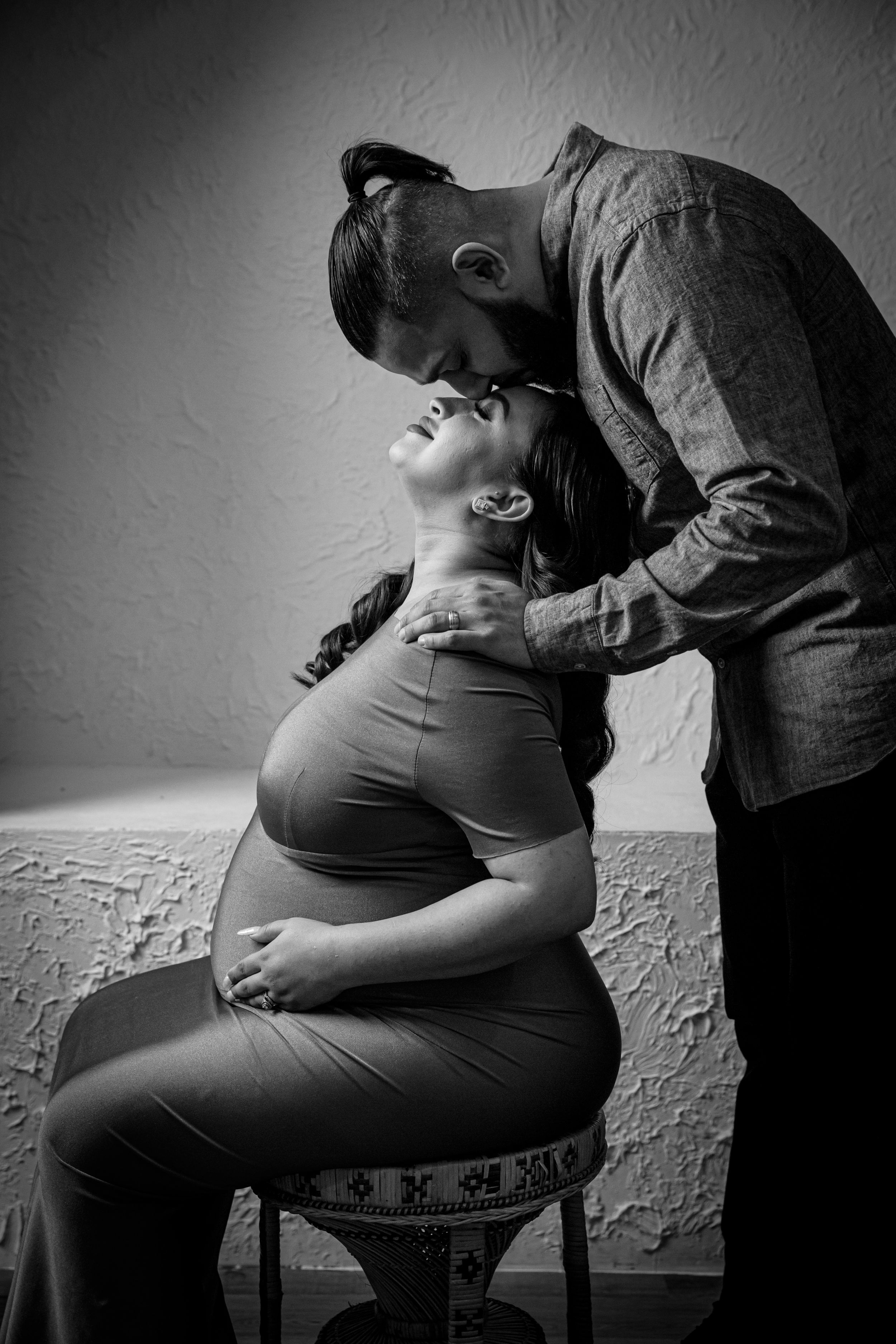 Black and white intimate maternity photoshoot showing tender moments between expecting parents.