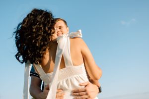 A joyful embrace captured against a bright blue sky.