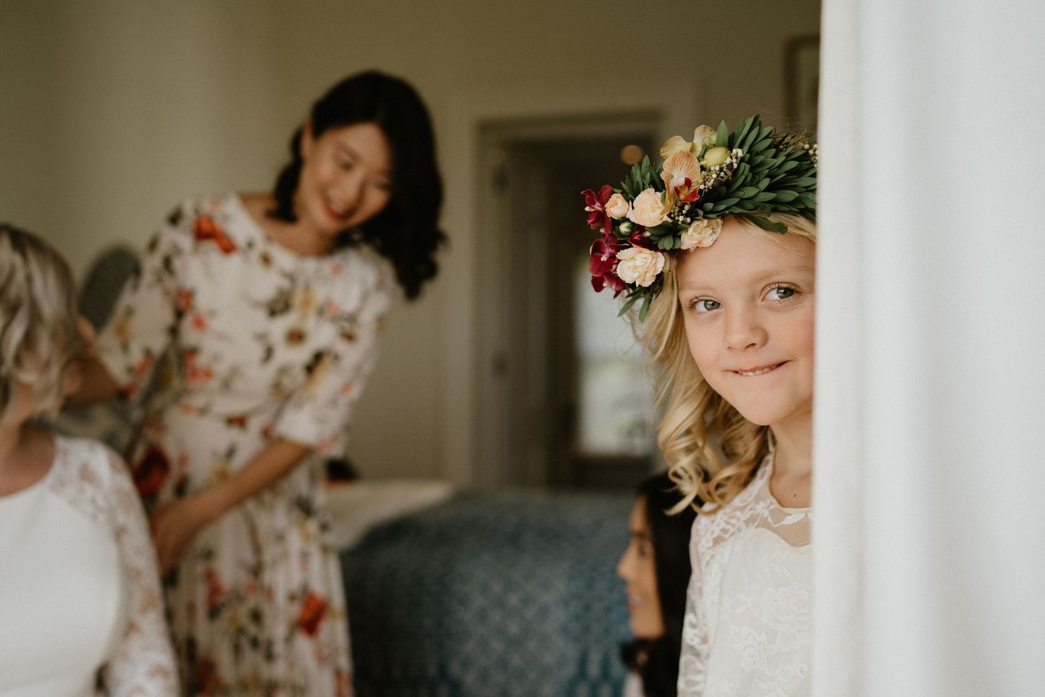 Wedding preparation scene with flower girl and attendant getting ready.