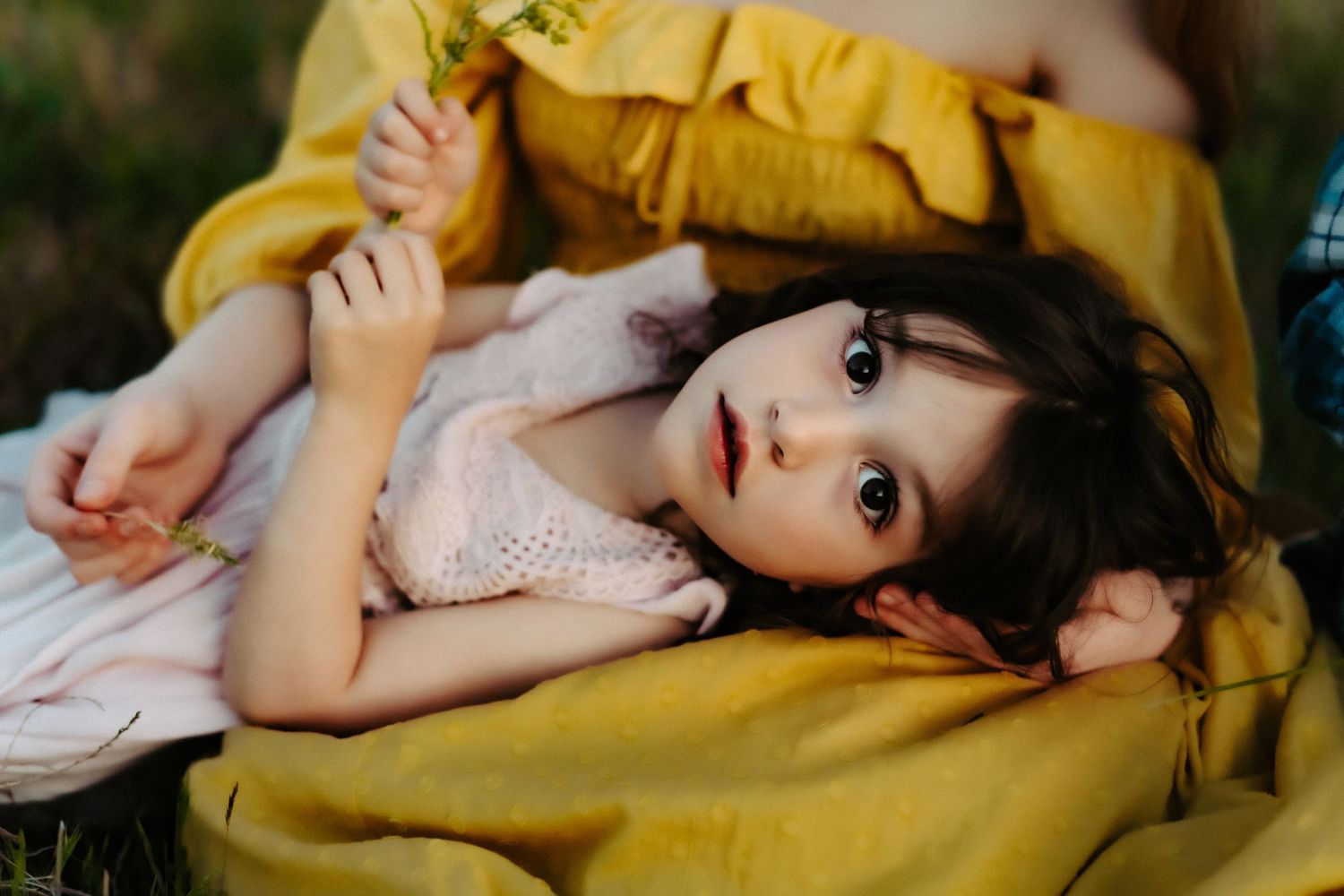 A close-up portrait in warm sunlight with yellow and pink clothing.