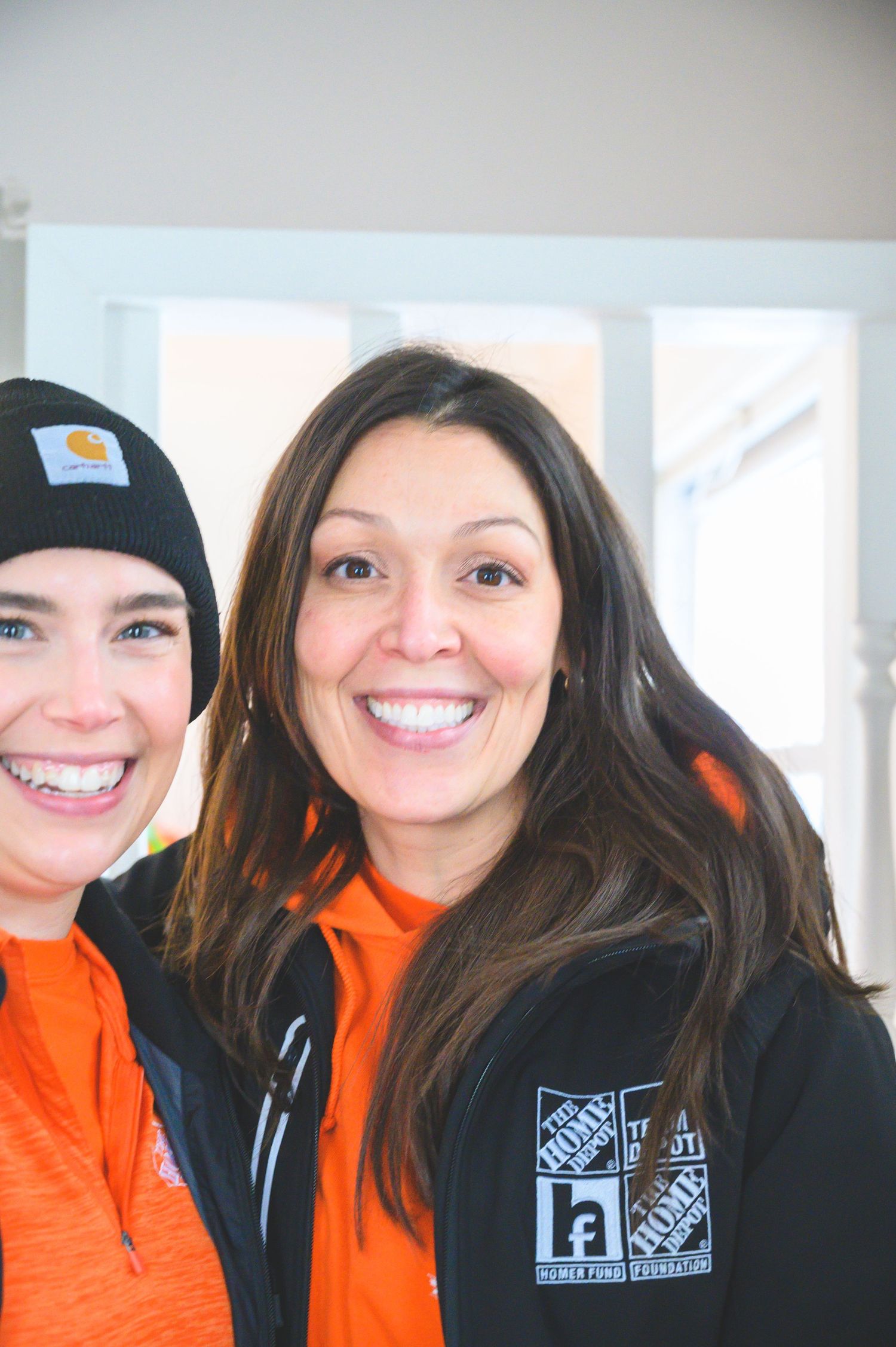Two people in Home Depot uniforms smiling together during painting project.