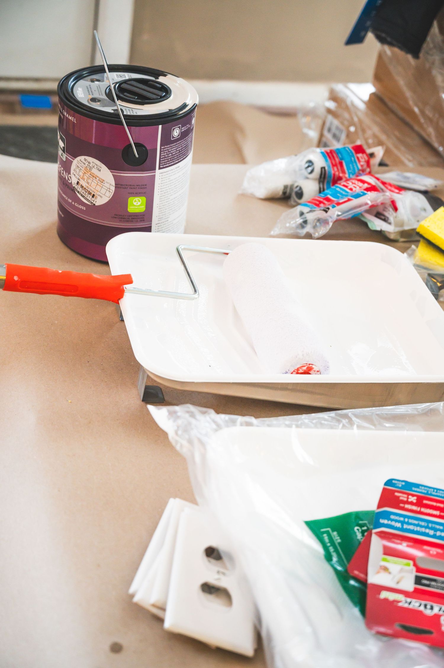 Paint supplies and tools laid out on a surface for a home improvement project.