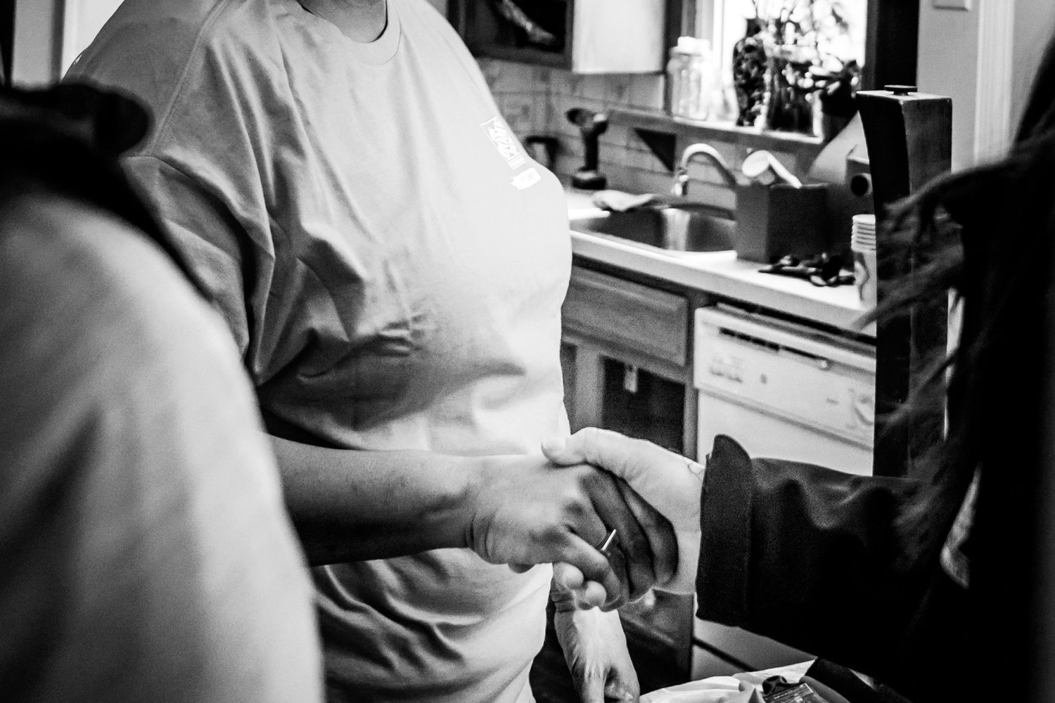 Person working with tools at wooden workstation in black and white photo.