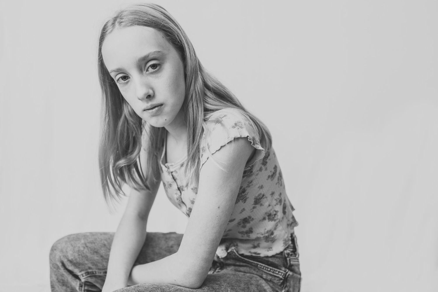 Black and white artistic portrait of someone in casual attire with a pensive expression.