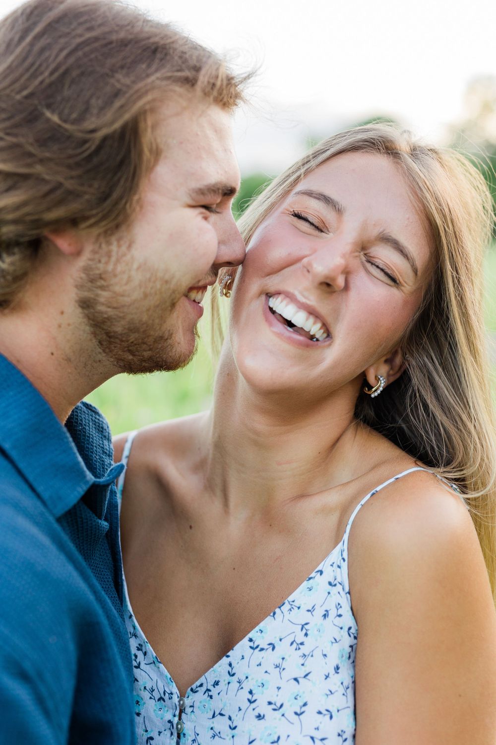 Intimate close-up of a couple sharing a joyful laugh outdoors.