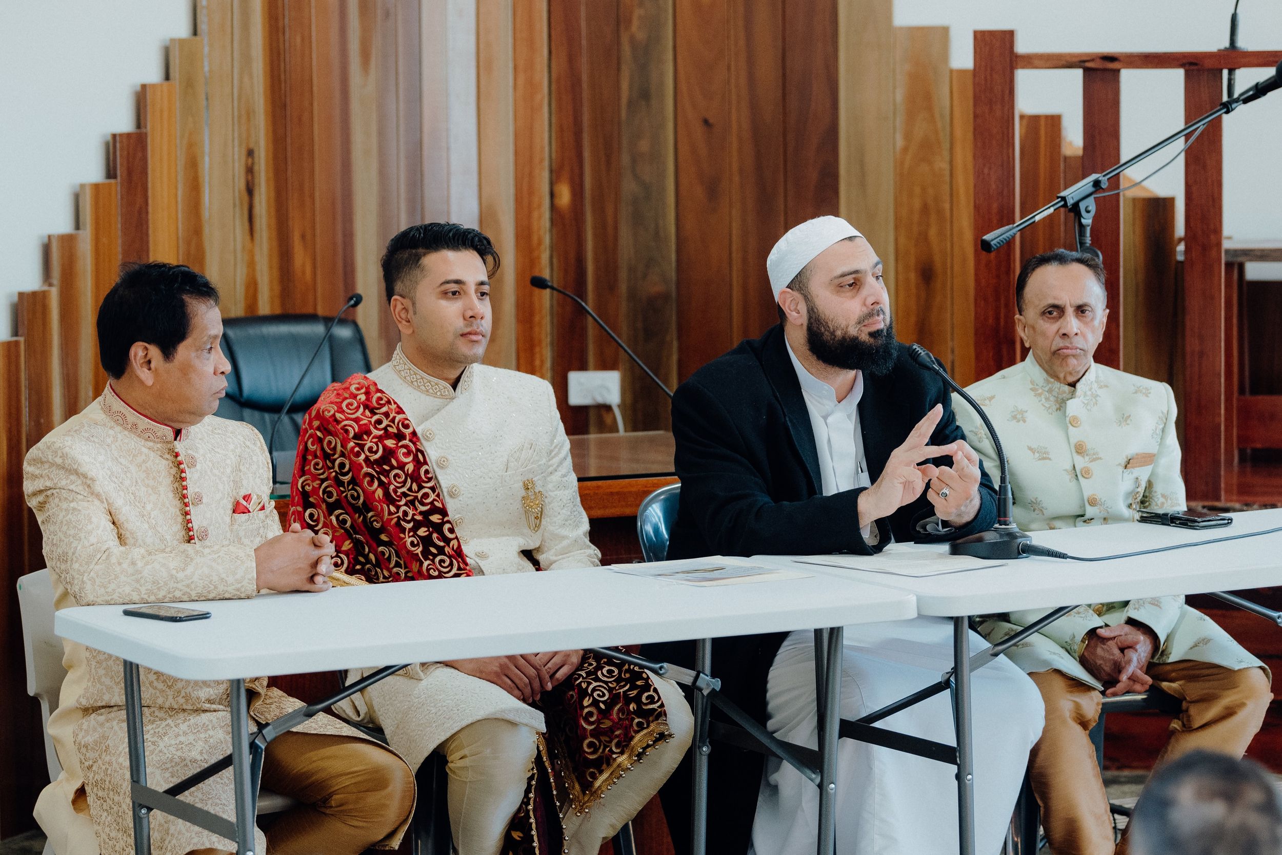Four people seated at a conference table during what appears to be a formal meeting or discussion.
