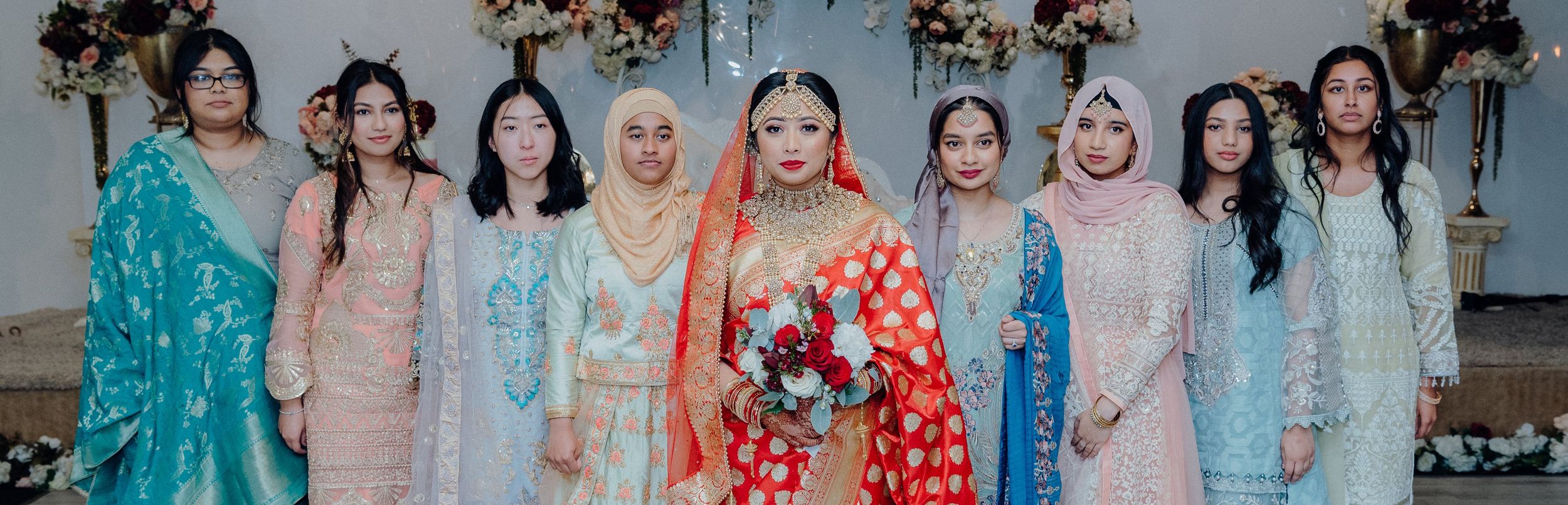 Group photo showing attendees in colorful traditional attire at a wedding celebration.