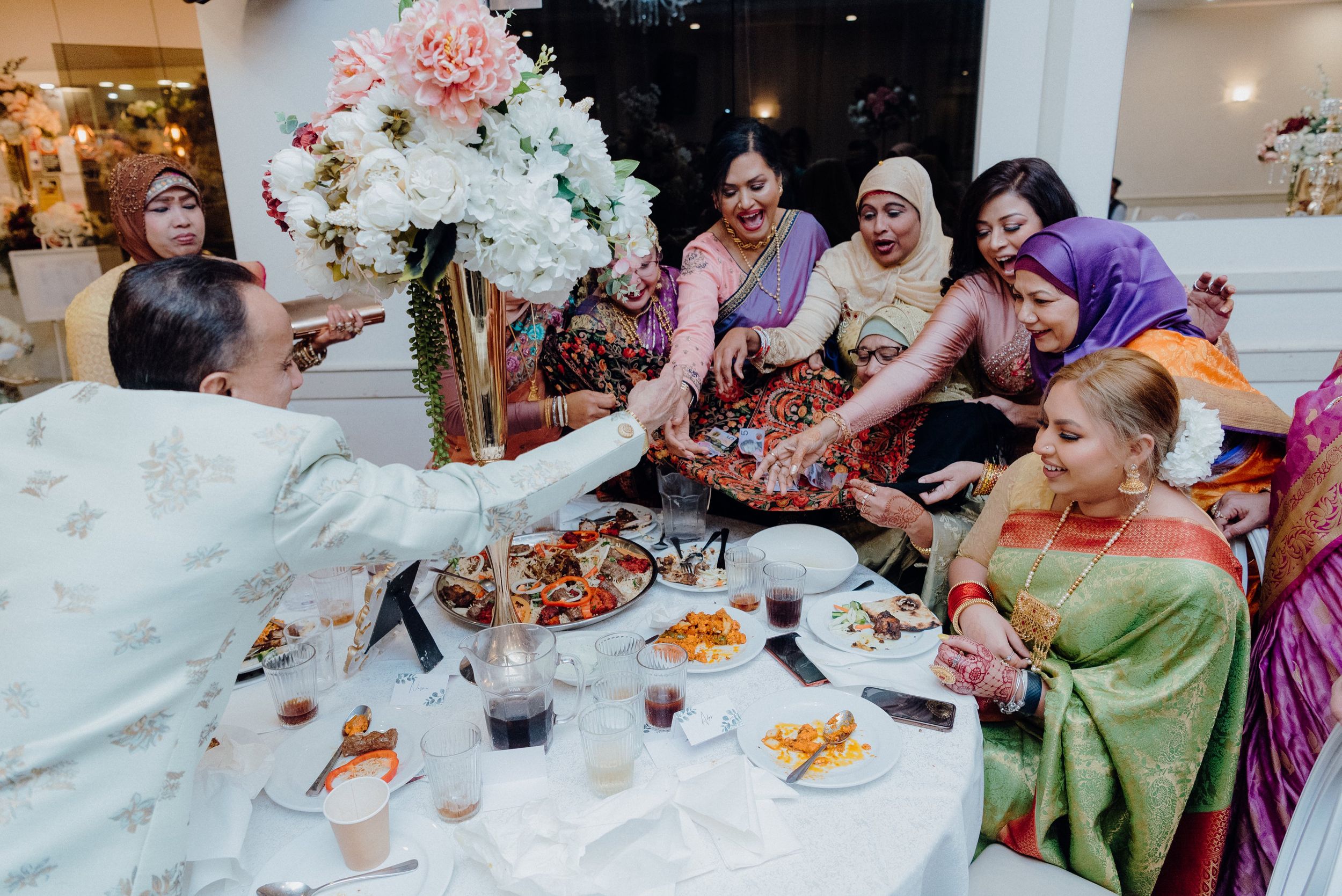 Guests sharing a traditional wedding feast with elaborate table settings and decorations.
