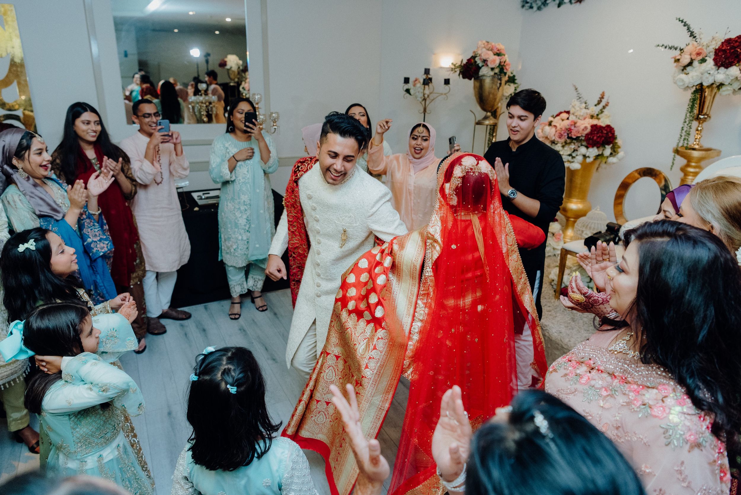 Wedding celebration with guests dancing and enjoying festivities in a decorated venue.