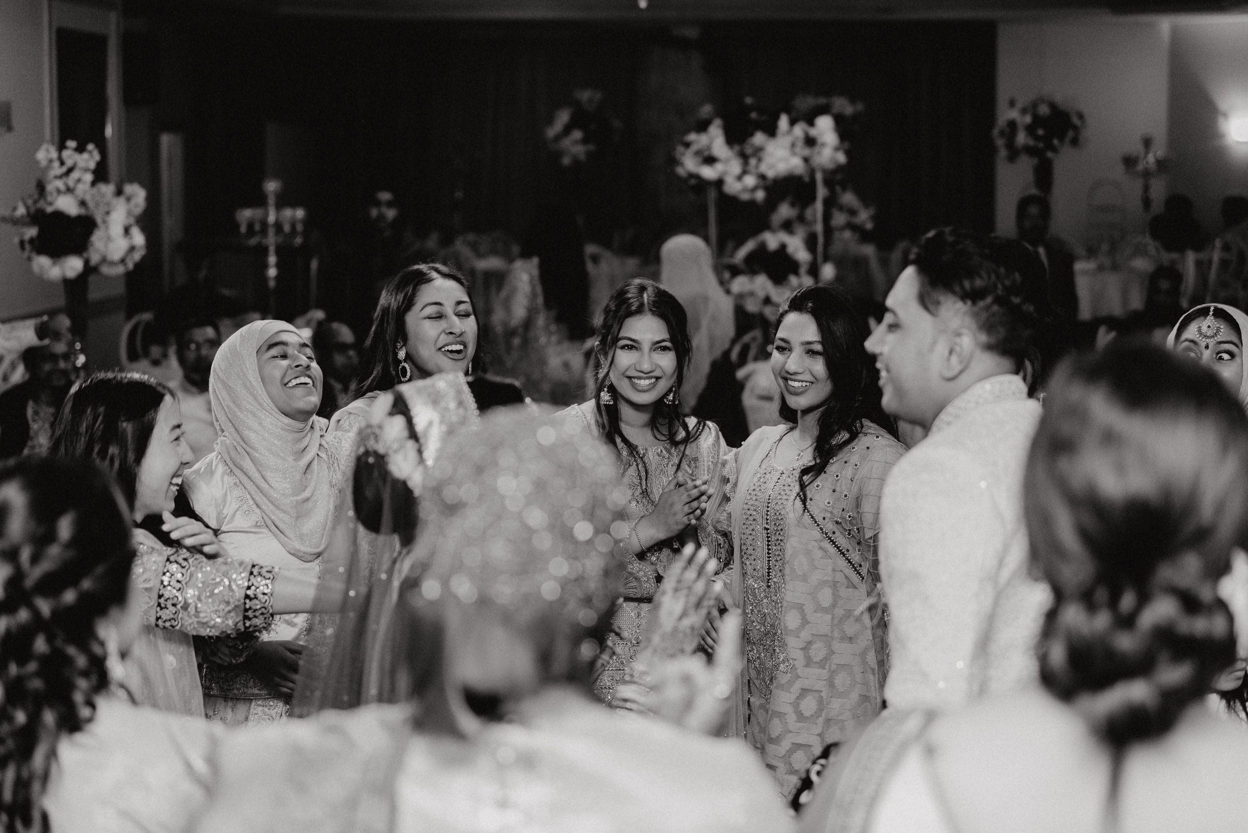 Black and white photo of wedding guests celebrating during the reception.