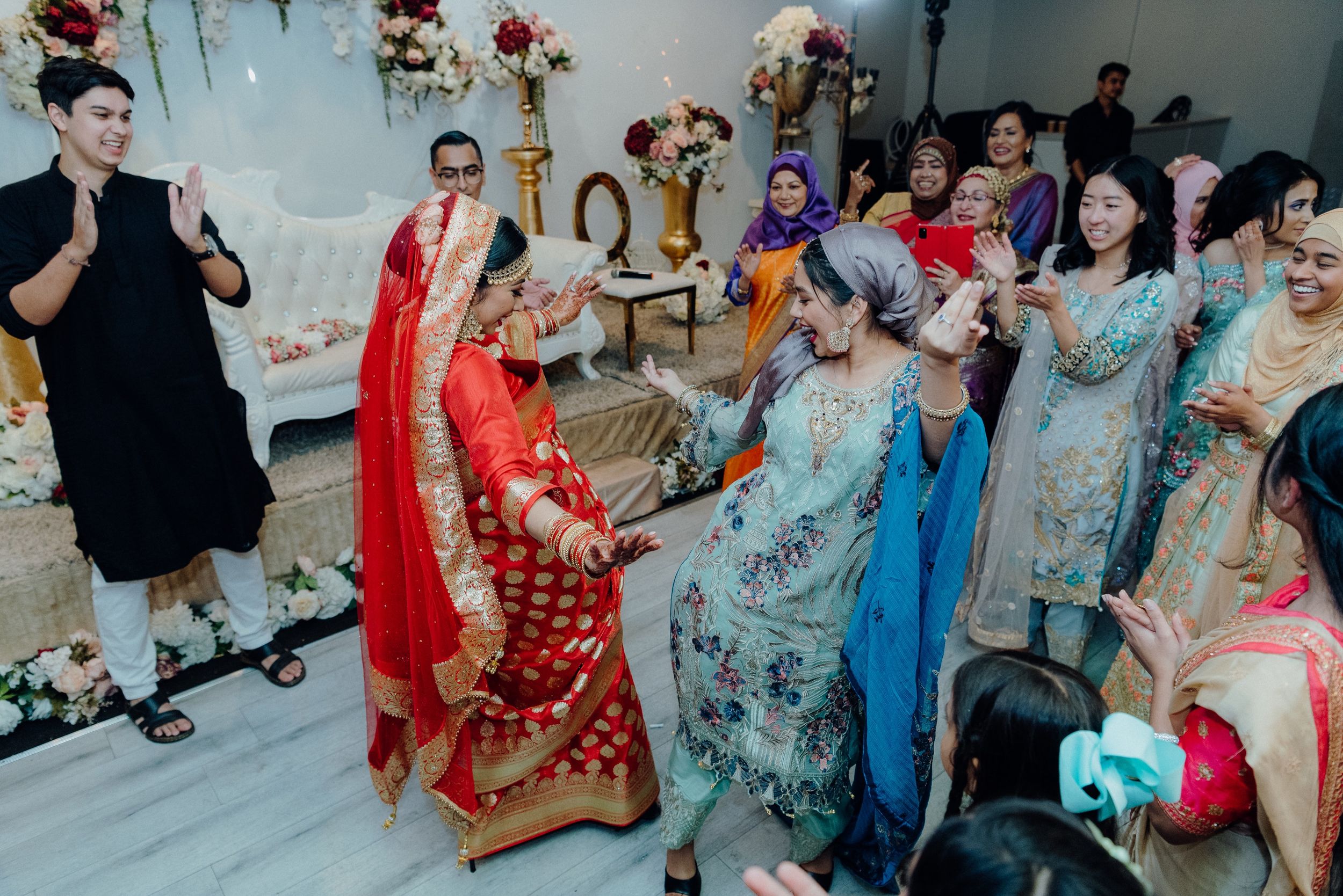 Wedding celebration featuring traditional dance performances in a decorated indoor setting.