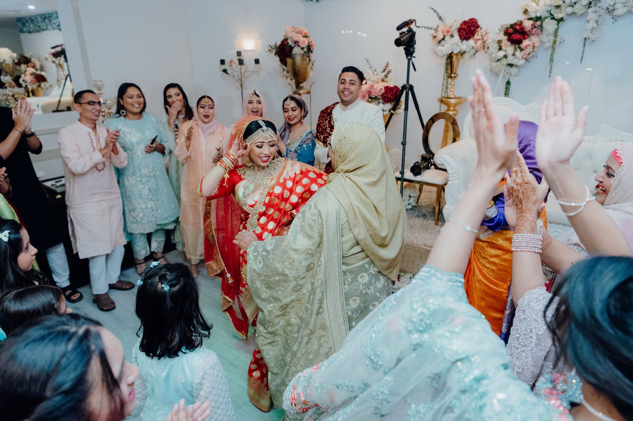 Wedding party and guests dancing and celebrating in a beautifully decorated venue.