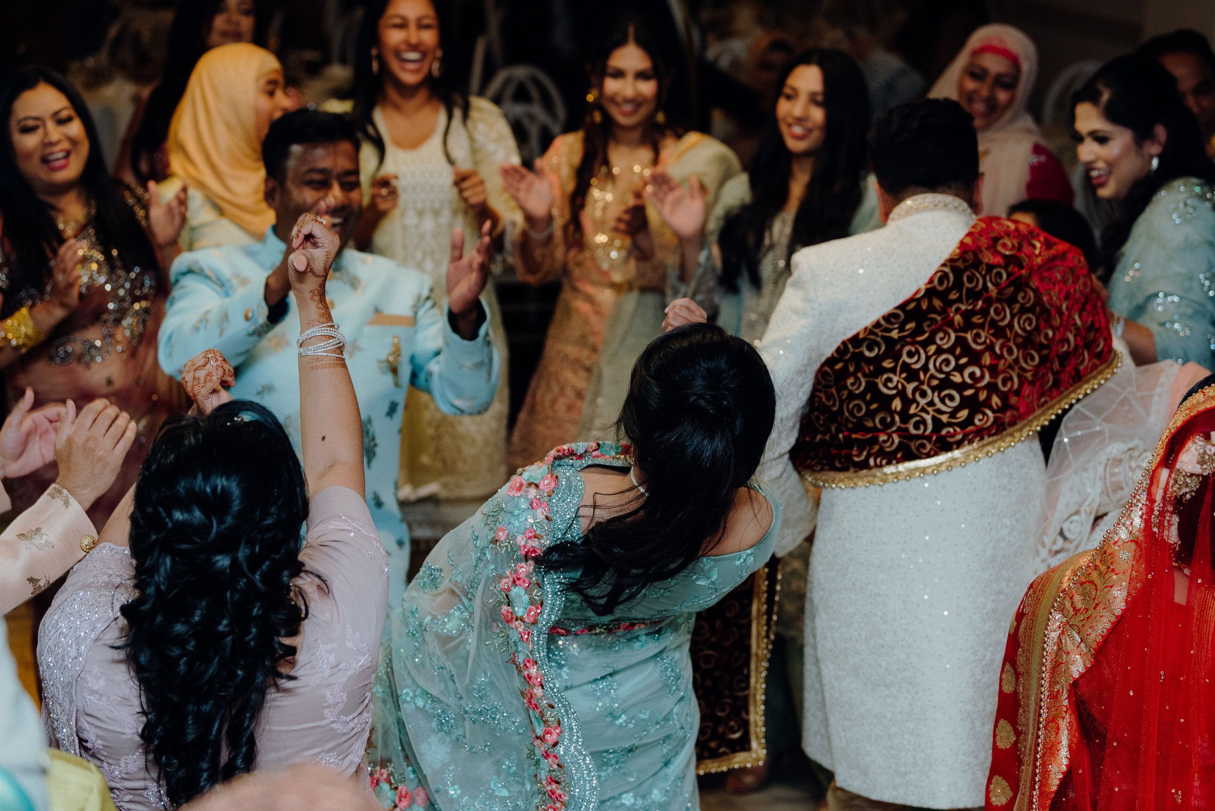 Wedding guests enjoying themselves on the dance floor in traditional formal wear.
