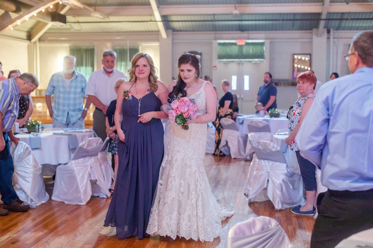 Wedding reception candid moments with guests in formal attire mingling in decorated venue.