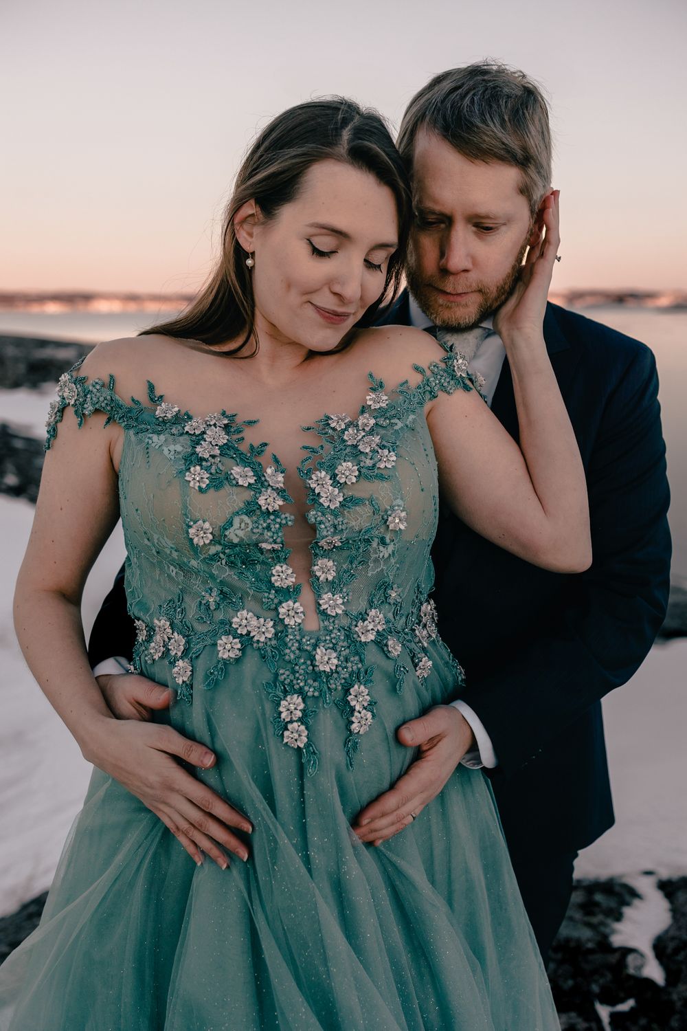 Intimate moment captured in formal wear against sunset backdrop.