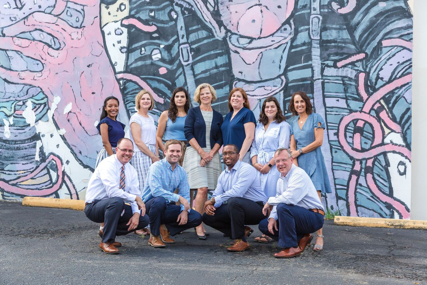 team photo in front of mural on the side of the building