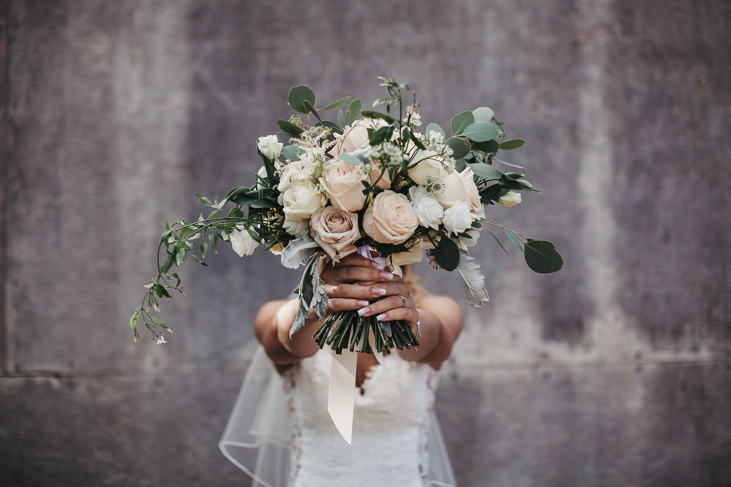 bride with bouquet in front of her face