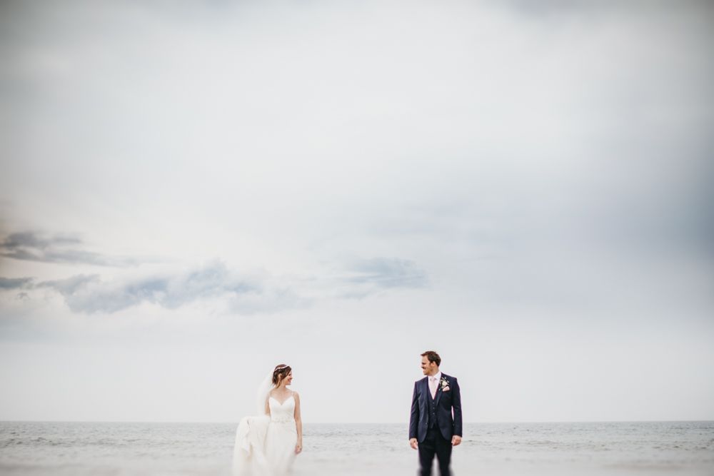 bride and groom looking at each other on beach