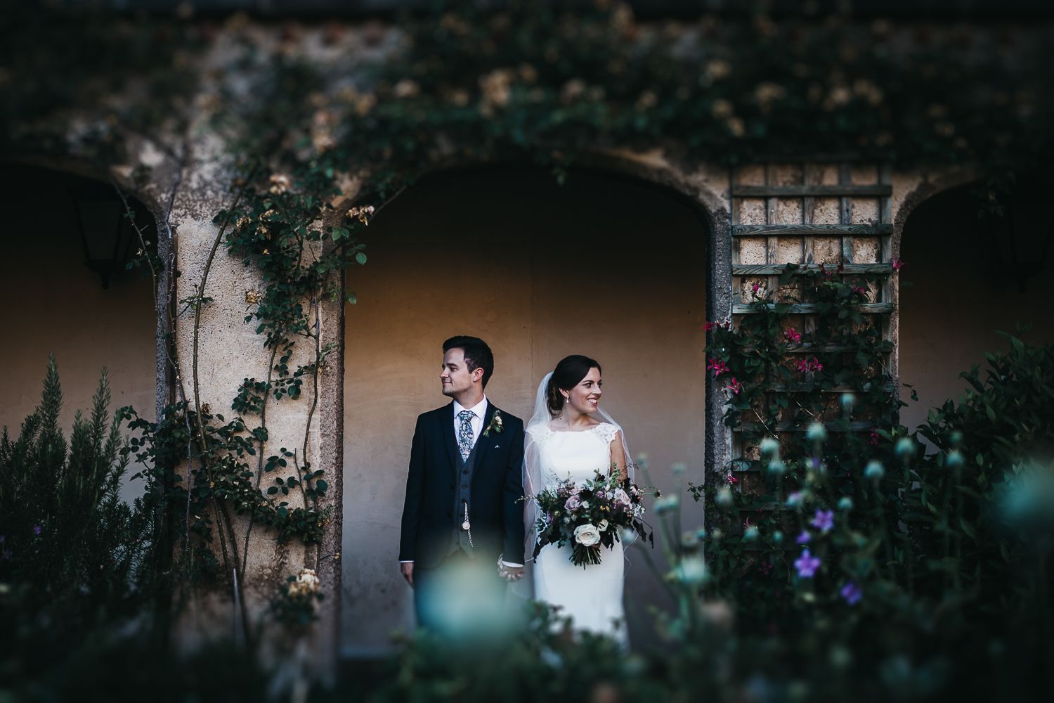bride and groom food under arches in walled garden at Holme Pierrepont Hall