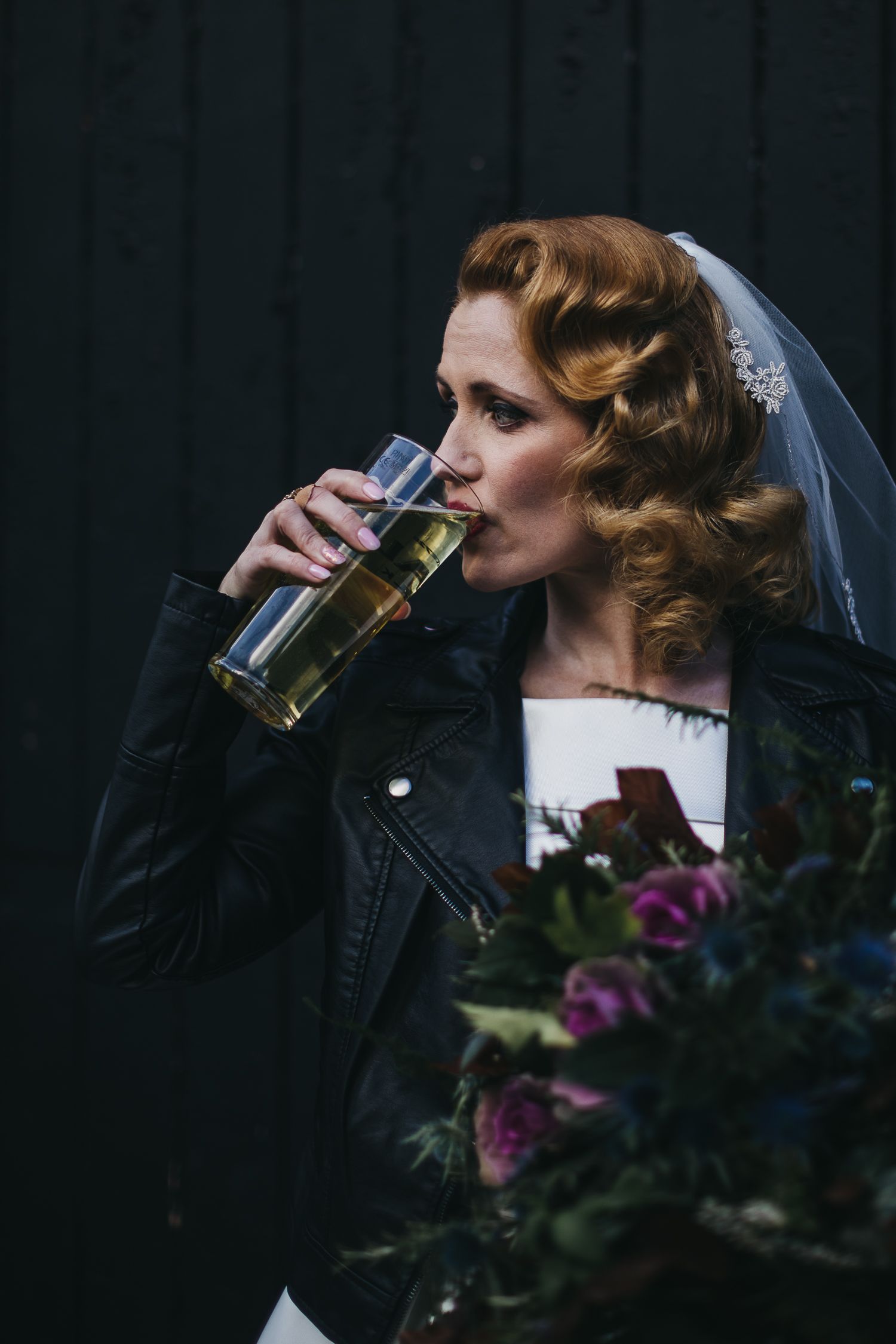 bride drinking a pint of lager wearing a leather jacket