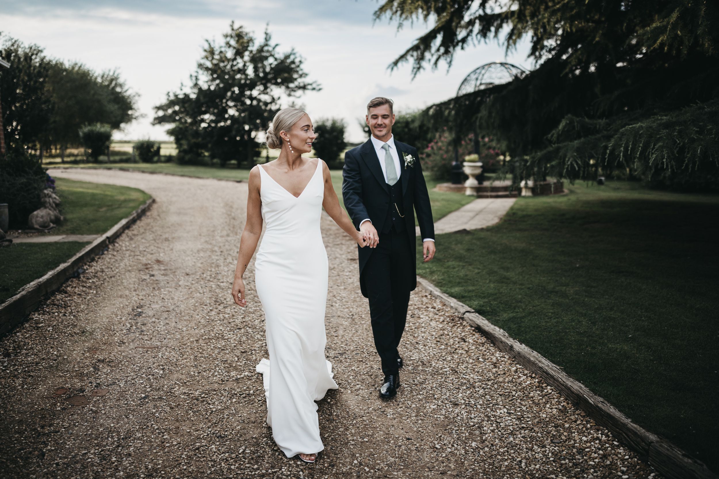 Wedding portrait of a couple walking towards the photographer at Swancar country farm wedding venue