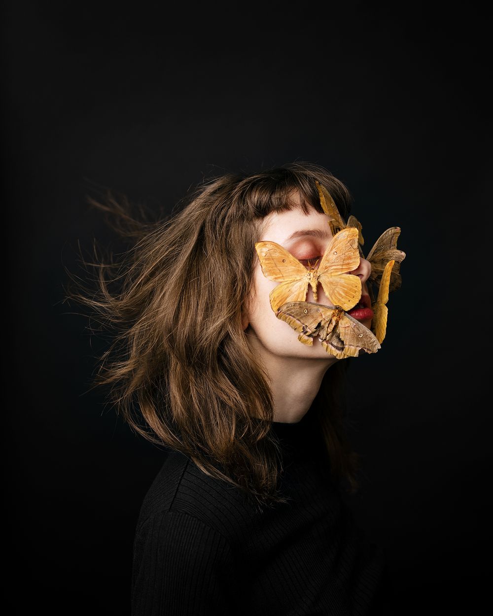 female portrait with moths on face