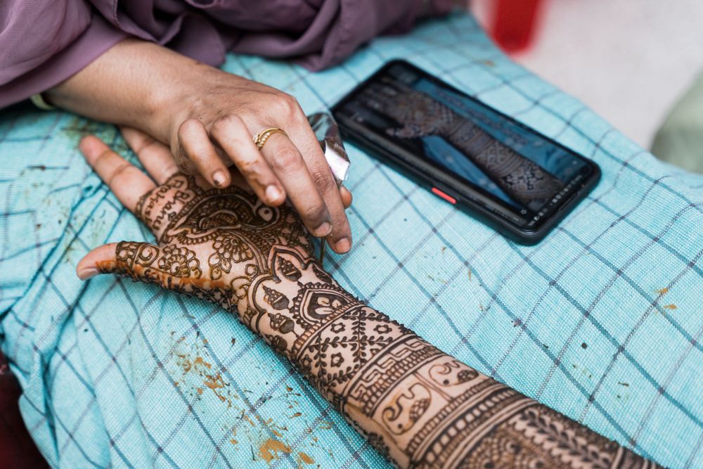 Detailed view of traditional mehndi artwork being applied on hands.