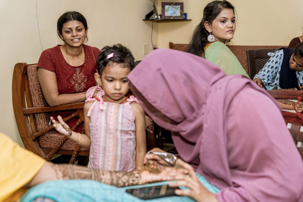 Traditional pre-wedding henna ceremony with women gathering indoors.