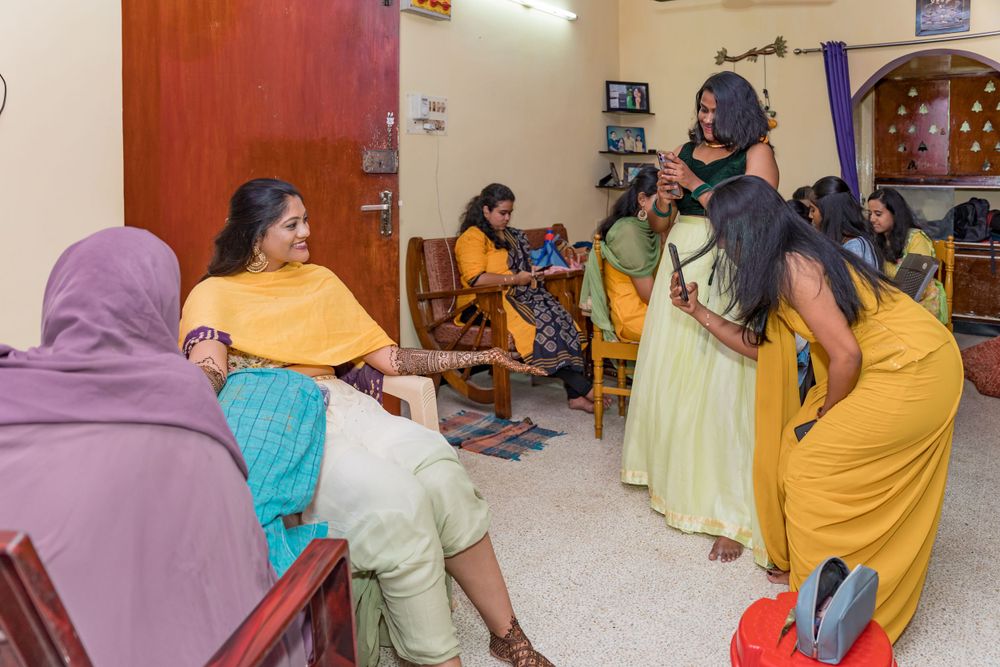 A celebratory scene with people in colorful traditional dress gathered in a home setting.