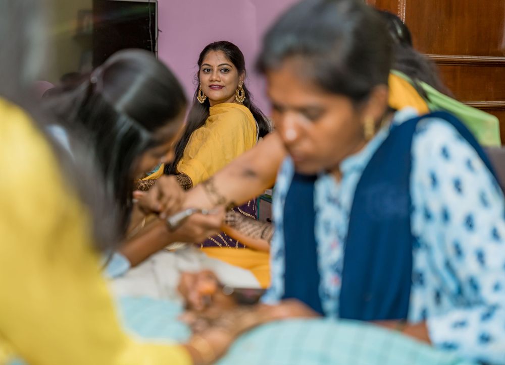 People gathered together applying traditional henna designs during a celebration.